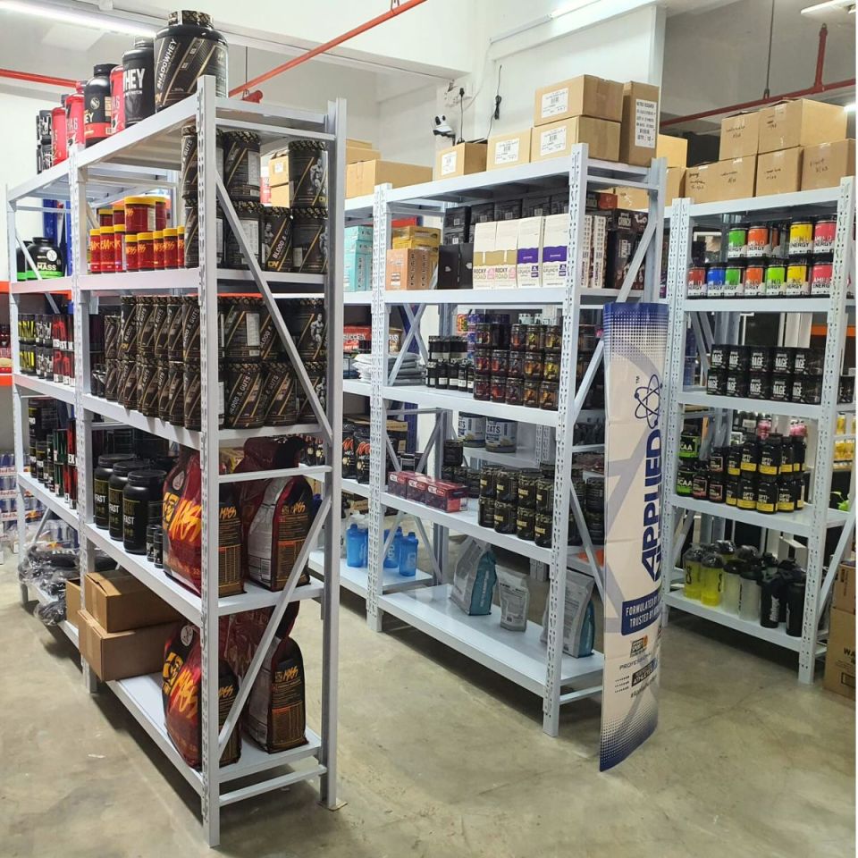 Retail stockroom with white metal racks full of products